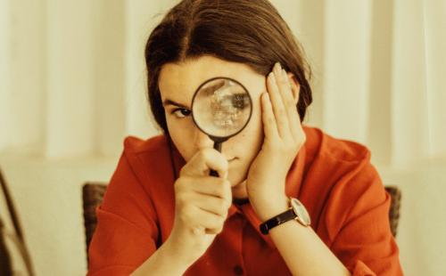 Woman looking through magnifying glass